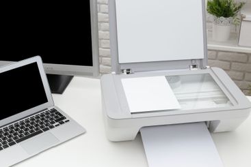 Modern home office setup featuring a printer and laptop...