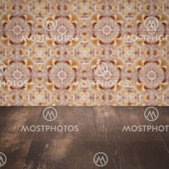 Wood table top and blur vintage ceramic tile pattern wall