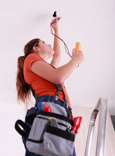 Woman measuring a wire's electrical current