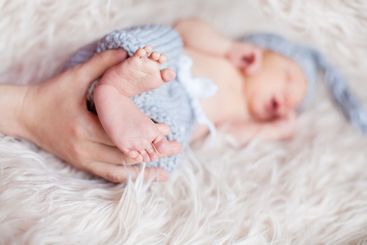 Little baby legs in parents hands