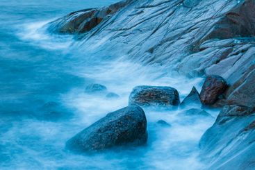 Coastal rocks and gentle waves in Sweden under a serene sky