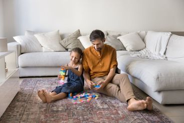 Mature father and little daughter playing creative game...
