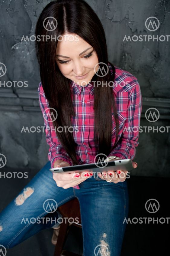 The young girl dreams and holds the touchpad
