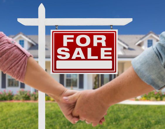 Couple Holding Hands In Front of New House