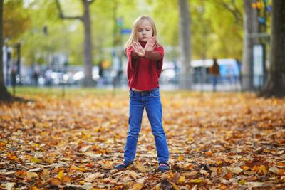Moody preschooler girl at autumn day outdoors