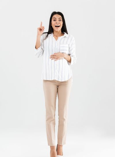 Full length photo of joyful pregnant businesswoman 30s...