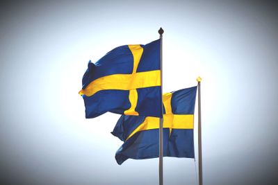 två svenska flaggor som vajar i vinden