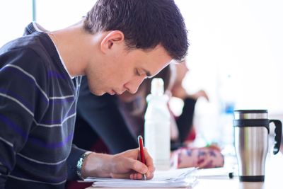 young, handsome male college student sitting in a...
