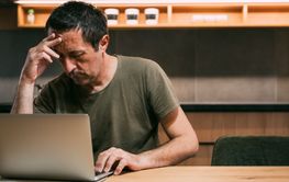 Tired exhausted freelancer working on a laptop computer...