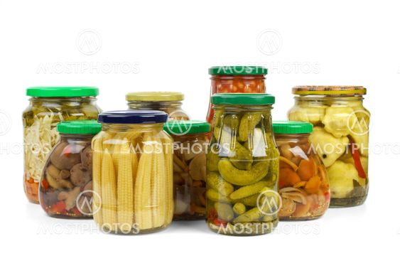 Glass jars with marinated vegetables and mushrooms