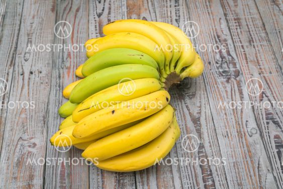 Fresh bananas on wooden table .