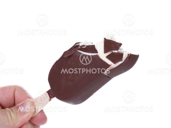 Hand holds bitten chocolate vanilla ice cream.
