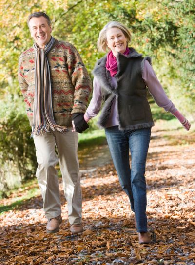 Senior couple walking through autumn woods