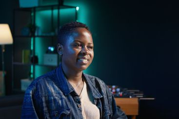 Portrait of happy woman sitting at home office desk in...