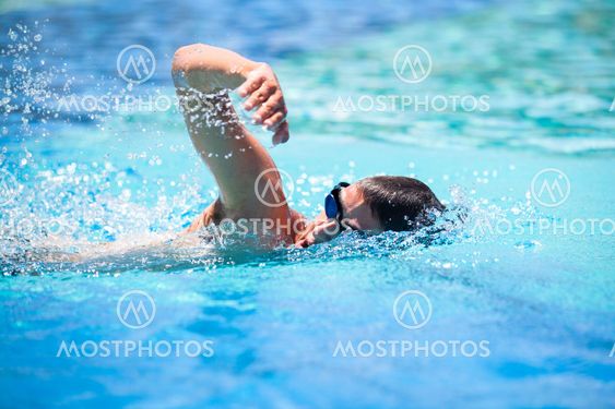 Young man swimming the front crawl in a pool