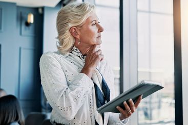 Business, thinking and woman with tablet, window and...