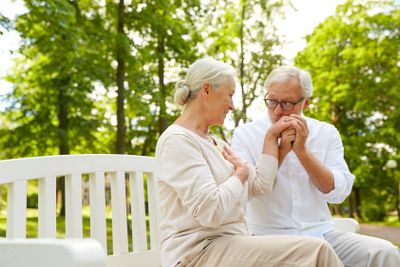 happy senior couple hugging in city park