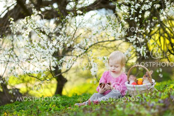 Adorable toddler girl eating chocolate bunny