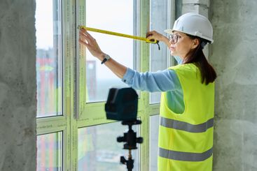 Industrial worker, woman measuring window with tape...