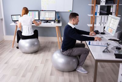 Businesspeople Working In Office Sitting On Fitness Ball
