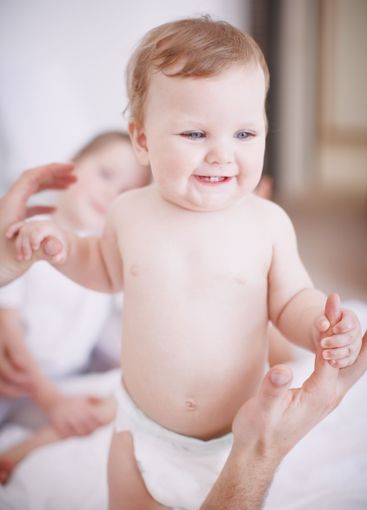 Baby, parents and playing with family in home, love and...