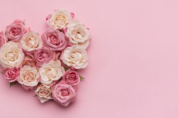 Heart of roses forming a romantic symbol on pink background