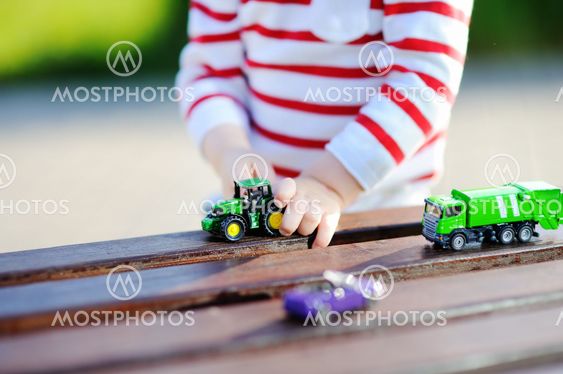 Toddler boy playing with toy cars close up