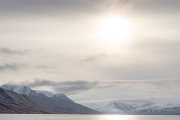 Sunset over snowy mountains and sea in Svalbard, Norway