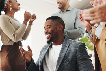 Man, celebration and team with applause by laptop for...
