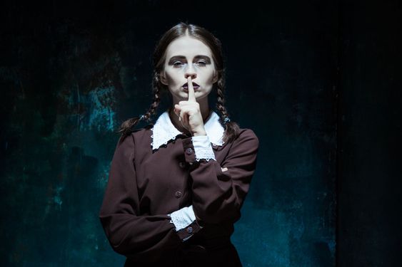 Portrait of a young girl in school uniform as killer woman