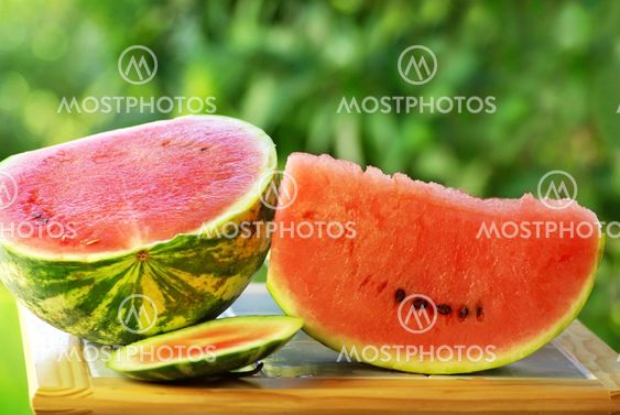 Watermelon and slice on table.