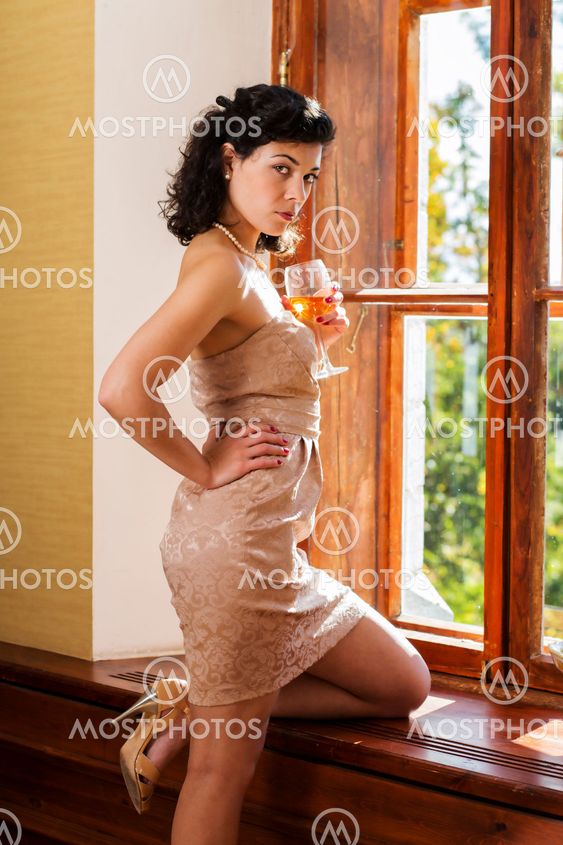 Pretty woman on supports knee on sill