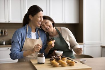 Mother and daughter decorating just prepared cupcakes...
