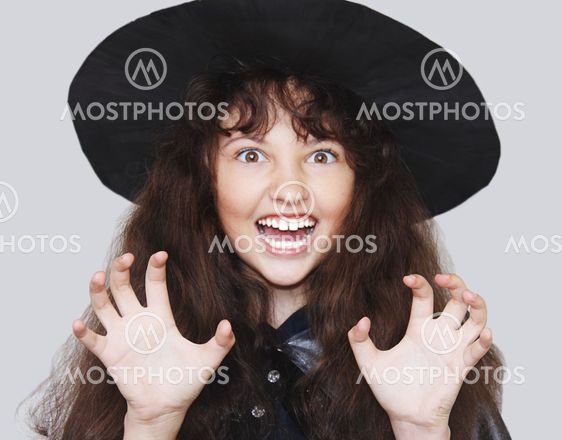 Young witch with a threatening gesture