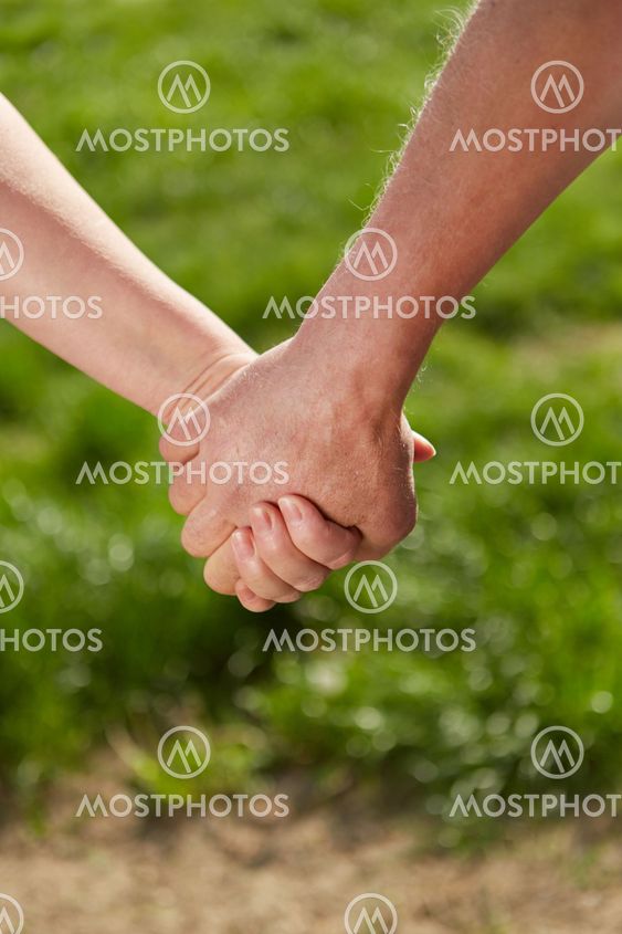 Old man and woman holding hands in nature