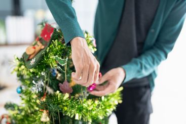 Happy hands Decorating Christmas tree for xmas holiday.