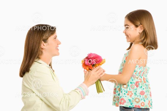 Girl giving mother flowers.