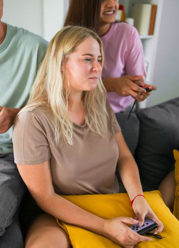 Cheerful group of friends playing video games together...