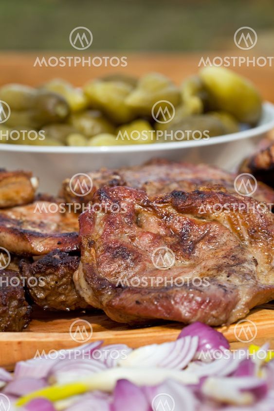 Grilled or barbecued pork meat with onion and pickles