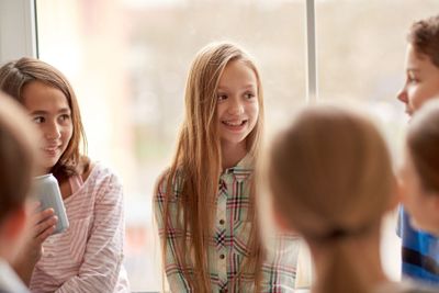 group of school kids with soda cans in corridor