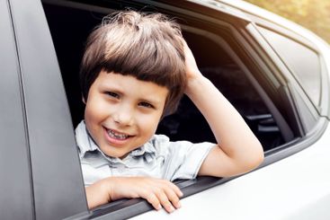 Cheerful caucasian small kid go on vacation by car and...
