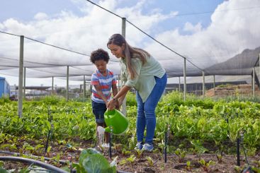 Field trip, student and teacher with watering can on...