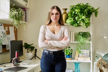 Portrait of young confident smiling woman in home interior