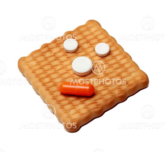 Medical pills and capsules on a cookie isolated on white background