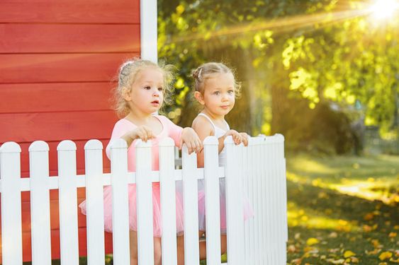 The two little girls at playground against park or green...