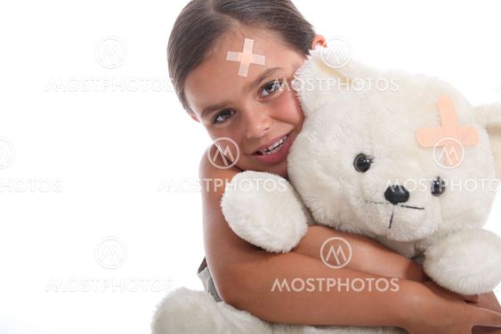 Young girl and her teddy bear, both wearing matching plasters on their foreheads