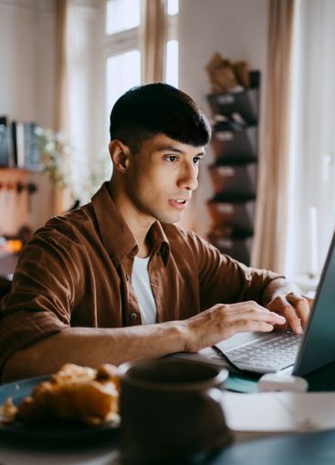 Male freelancer working on laptop at home office