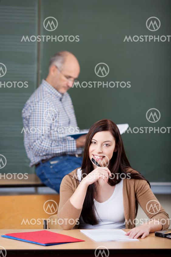 Female Student Smiling With Professor In Background