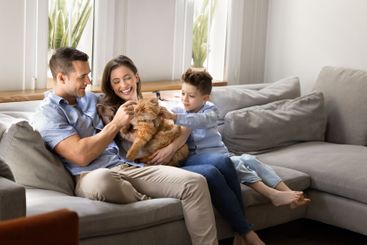 Positive family couple and cute little son cuddling...
