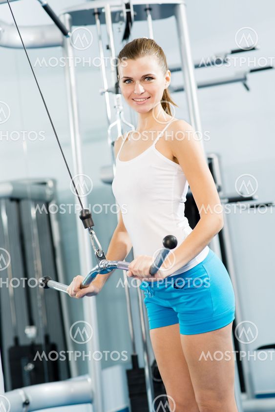 young woman doing body-building in the Gym